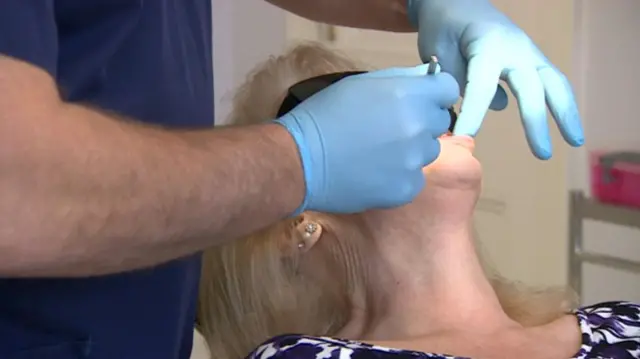 Dentist working on woman's teeth