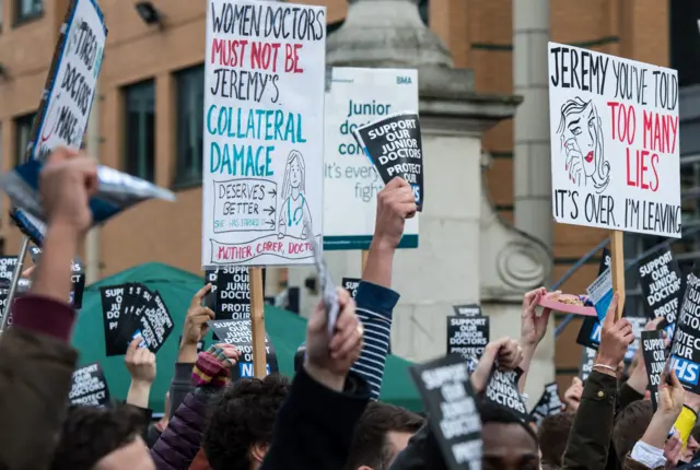 Doctors hold placards outside King's College Hospital, London