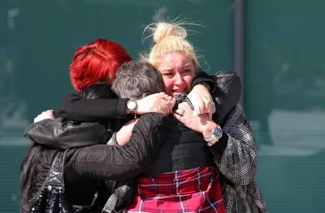 Families hug outside the court