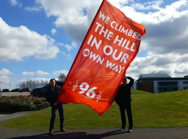 Hillsborough surviviors carry flag