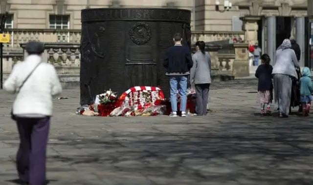 People pause at the Hillsborough memorial in Liverpool