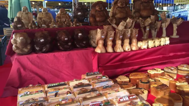 Market stall with various baked goods and wooden statues