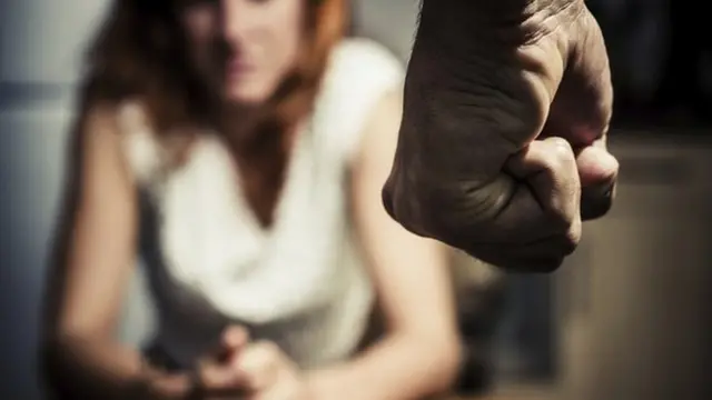 Blurred woman with clenched fist in foreground