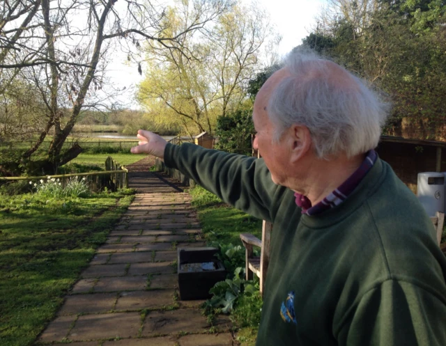 Geoff Doggett, pointing towards fencing and water