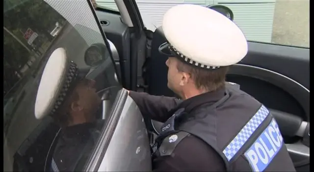 Police officer by open car door