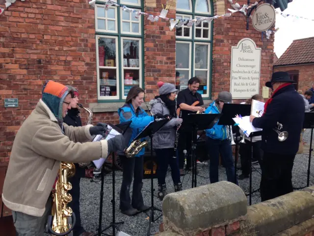 Band playing ahead of the arrival of the peloton