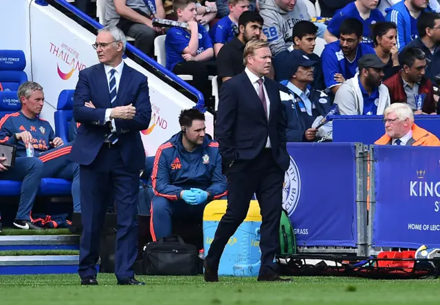 Both team managers watch play