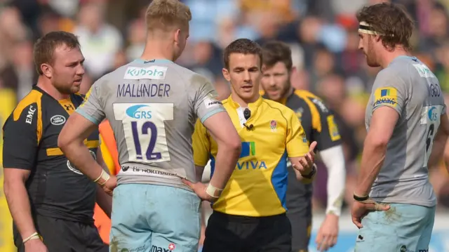 Referee Luke Pearce warns Harry Mallinder of Northampton Saints about his tackle on Christian Wade of Wasps