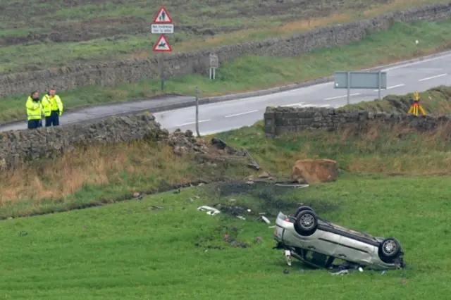 The injured driver's overturned car in a field