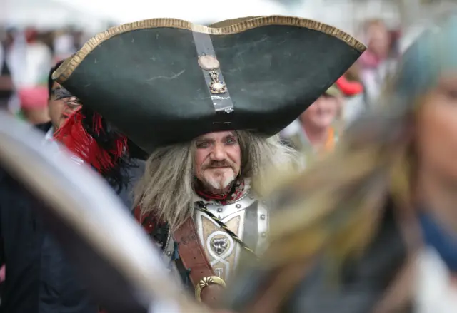 Terry English dressed as a pirate walks in the crowd as people gather to attempt to reclaim the Guiness World Record for the most pirates in one place, on the promenade in Penzance, on May 26, 2014 in Cornwall