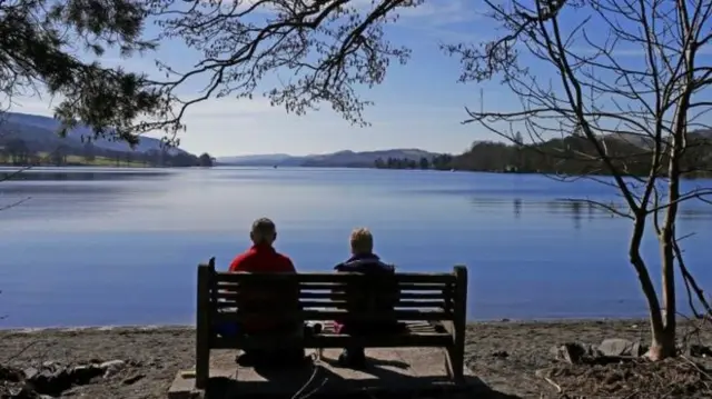 Couple on a bench in front of a lake