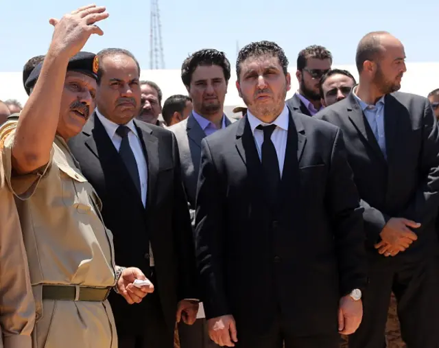 Khalifa Al-Ghweil (C) listens to the explanations of the Army Chief of Staff, Jadallah al-Abidi (L) during the Libyan Army Officers 5th Forum, on June 3, 2015