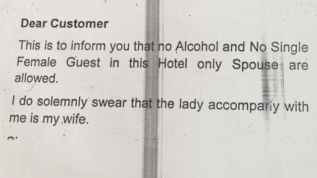 Note guests are required to sign when registering at a hotel in Kano, Nigeria