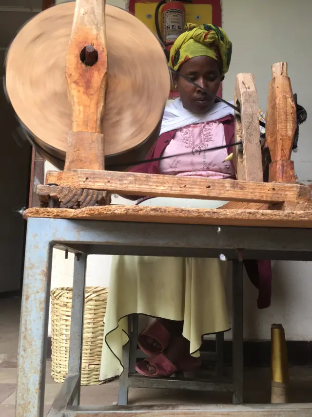 Woman works at a wooden loom