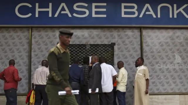 Customers trying to get money out of a Chase Bank cash machine in Nairobi, Kenya