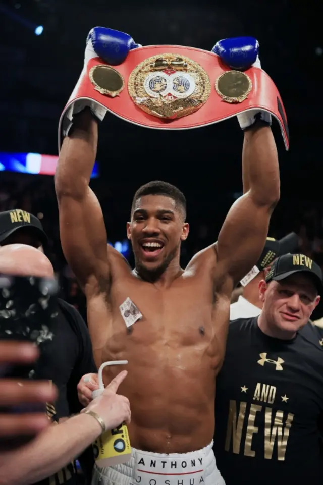 Anthony Joshua raises the belt above his head