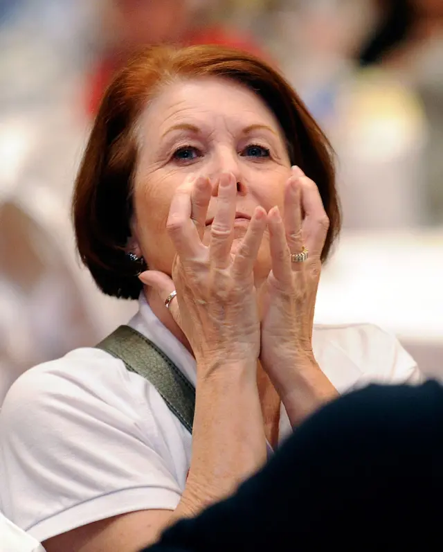 A lady watches on through her fingers