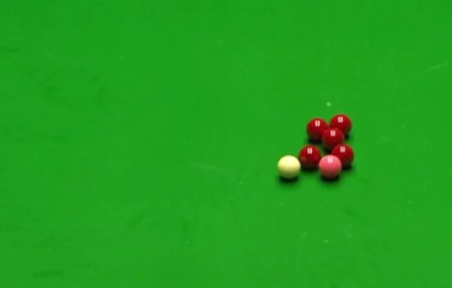 The cue ball narrowly misses a pack of reds