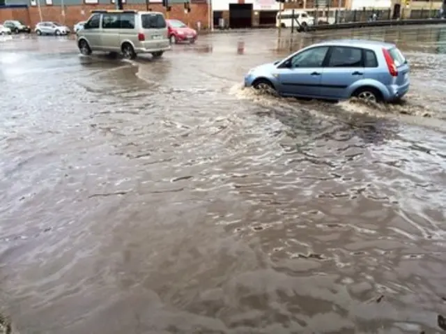 Cars driving through flooded streets