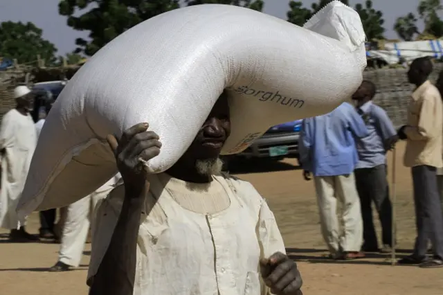 Sudanese displaced man carries humanitarian aid supplies