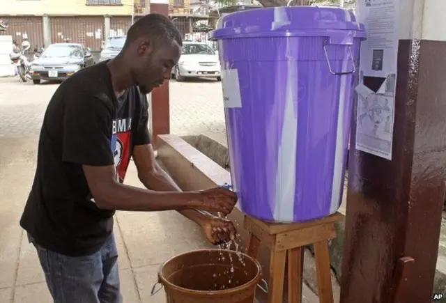 Man washes hands under tap