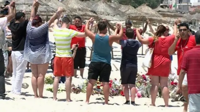 People hold hands at beach