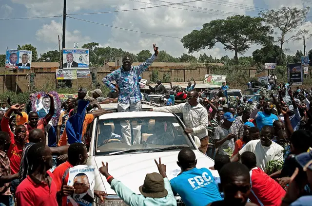 Kizza Besigye waves to supporters as his convoy drives towards Kampala, on February 16, 2016