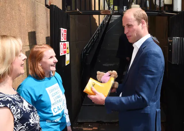 Prince William with a teddy and RNLI wellington boots for his children