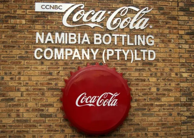 A picture taken on May 11, 2016 in Windhoek shows the logo at the entrance of the Coca Cola Namibia Bottling Company (Pty) Limited