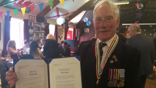 Jim Green holding medals