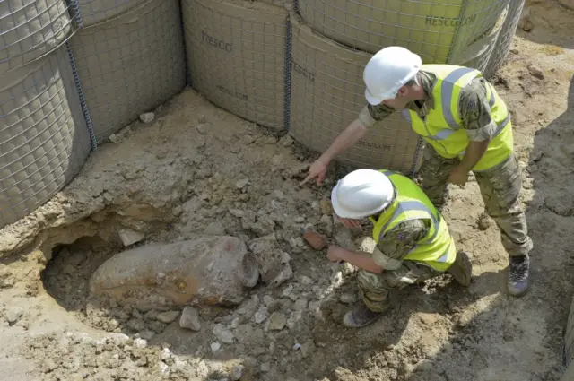 Army officers examining bomb