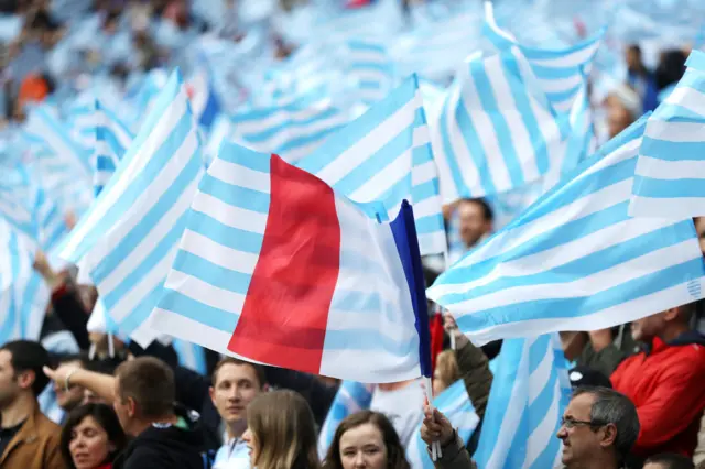 Supporters wave flags in the stands