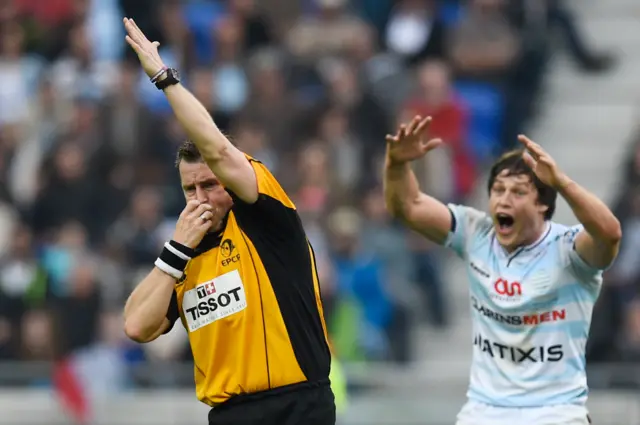 Referee Nigel Owens blows a whistle to give Saracens a penalty