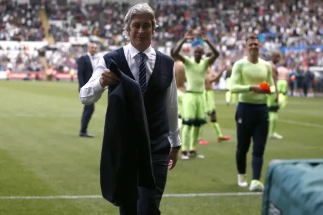 Manuel Pellegrini hands his jacket to a supporter