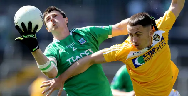 Fermanagh's Mickey Jones beats Antrim forward Brian Neeson to the ball