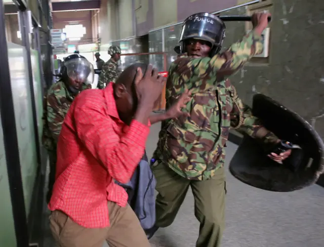 Policemen beat a protester inside a building during clashes in Nairobi, Kenya May 16, 2016.