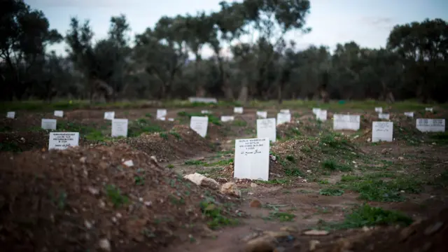 Tombstones are pictured on migrant graves, who died during the attempt to reach the Island of Lesbos, at a newly built cemetery on March 11, 2016 in Kato Tritos, Greece