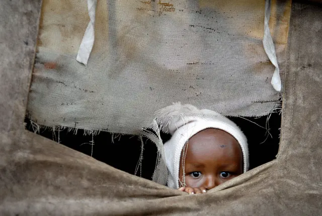 Brian Mwangi, a two-year old Kenyan boy, plays inside a tent in a camp for internally displaced people set up in Nairobi's Mathare slum, Kenya, on February 8, 2008