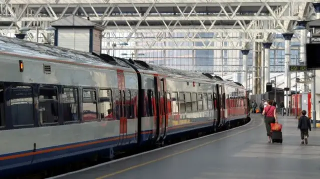 A generic picture of a child and parent walking along a train platform