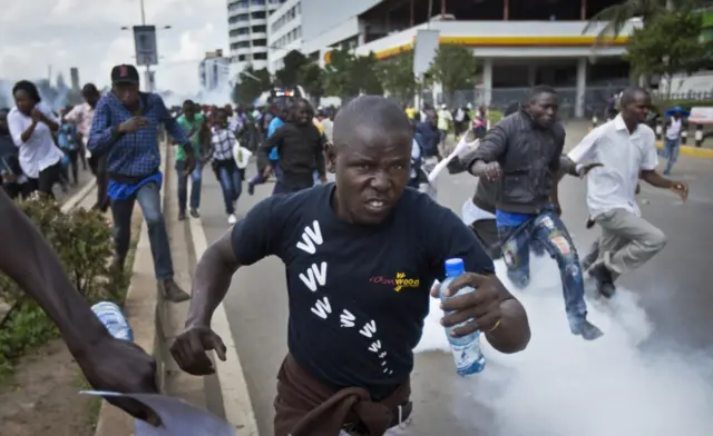 Opposition supporters flee from tear gas grenades fired by riot police, during a protest in downtown Nairobi, Kenya Monday, May 16, 2016.