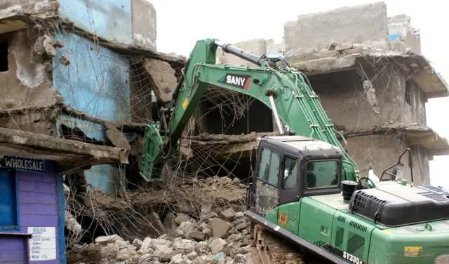 Digger destroying houses