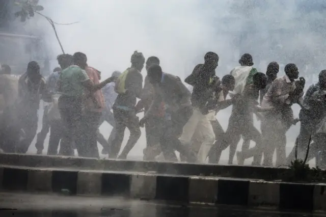 Protesters run away from tear gas