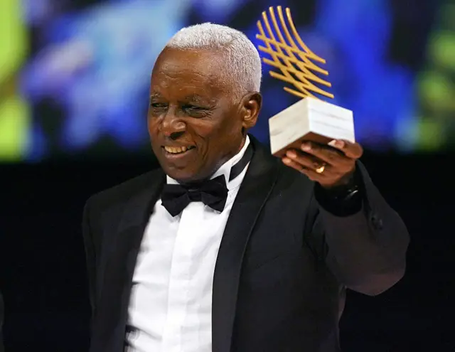 Woldemeskel Kostre holding a trophy