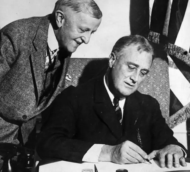 Roosevelt signs the Emergency Banking Bill with Secretary of the Treasury William Woodwin in March 1933.