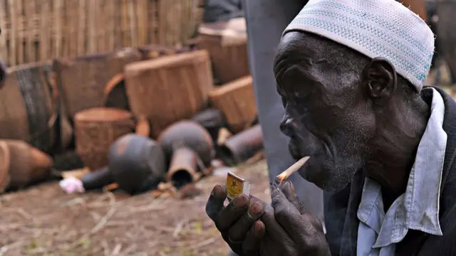 Ugandan man lights up cigarette