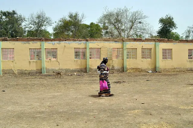 A mother of an abducted Chibok girl walks on April 14, 2015 past the school hostel where 219 schoolgirls by Boko Haram Islamists the girls were abducted ater a gathering to mark the one-year anniversary of their abduction in the northeastern Nigerian city of Chibok in Borno State