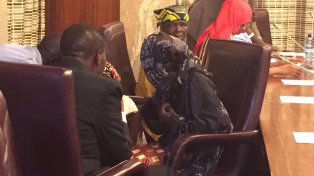 Amina Ali sitting in a leather-backed chair