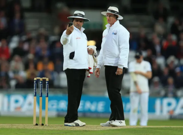 Umpires measure the light