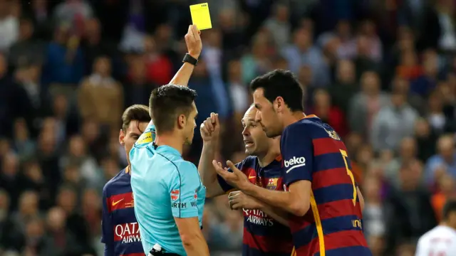 The referee shows the yellow card