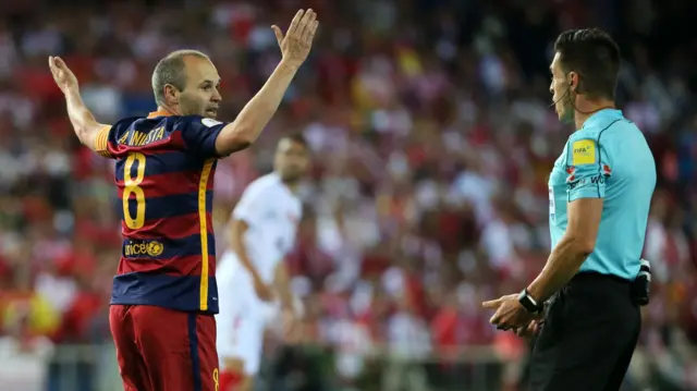 Andres Iniesta gestures to the referee